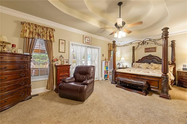 carpeted bedroom with access to exterior, a tray ceiling, a ceiling fan, and ornamental molding