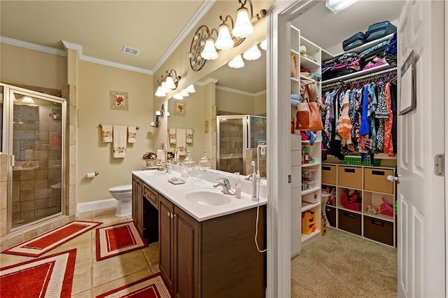 bathroom featuring visible vents, double vanity, a stall shower, a walk in closet, and crown molding