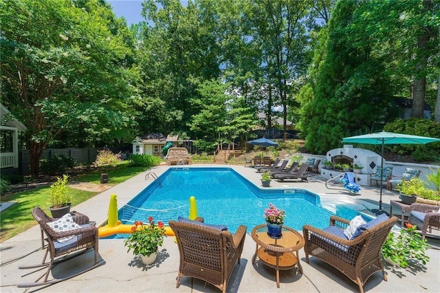 outdoor pool featuring a patio area, an outdoor structure, and fence