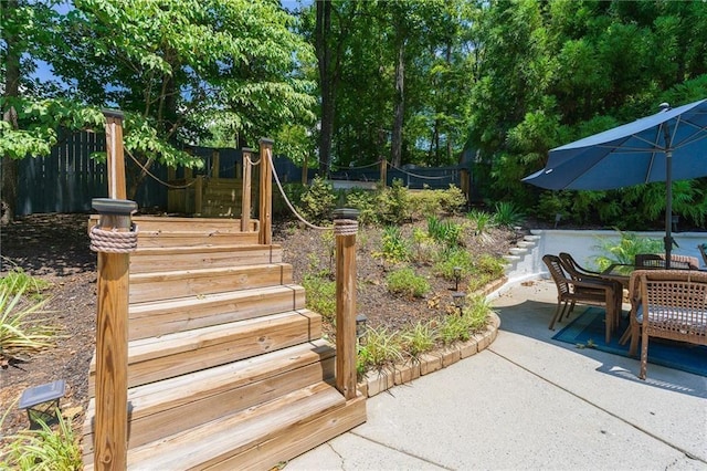 exterior space with outdoor dining area, stairway, and fence