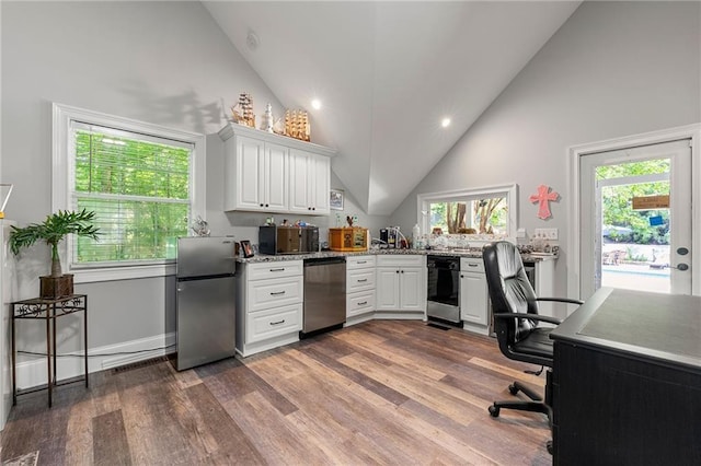 office area with dark wood-type flooring, a healthy amount of sunlight, and high vaulted ceiling