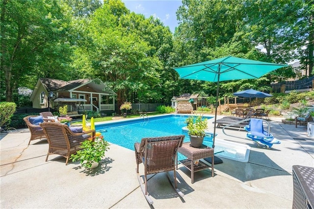 pool with a patio area and fence