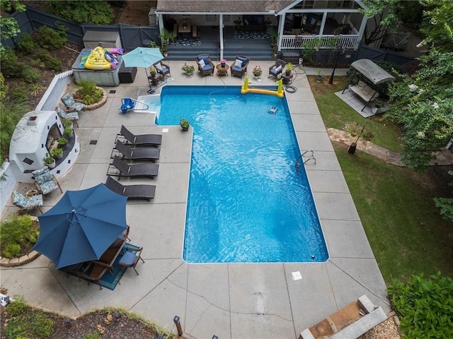 view of swimming pool featuring a fenced in pool, fence, and a patio