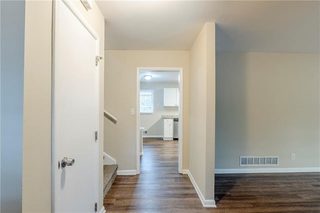 corridor featuring dark wood-style floors, visible vents, stairway, and baseboards