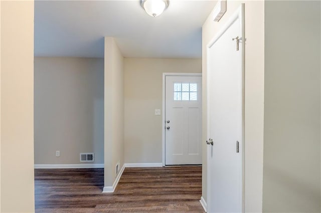 foyer entrance with baseboards, visible vents, and dark wood-type flooring