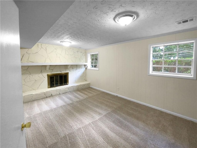 unfurnished living room with carpet, a textured ceiling, and a fireplace