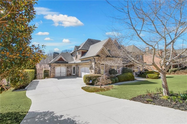 french country style house featuring stone siding, concrete driveway, an attached garage, and a front lawn