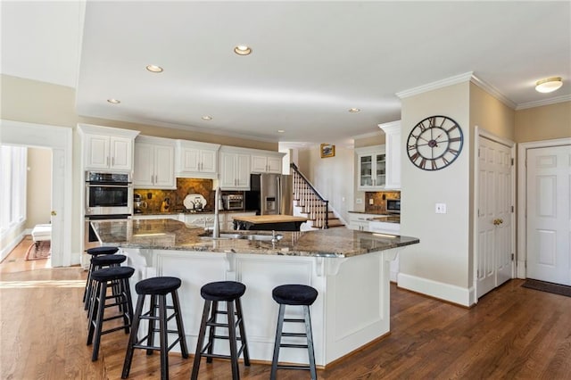 kitchen with a large island, a kitchen breakfast bar, and white cabinets