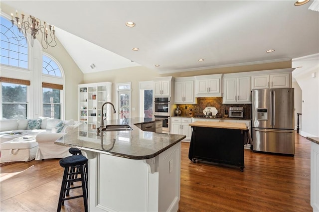 kitchen featuring sink, a breakfast bar area, appliances with stainless steel finishes, a large island, and white cabinets