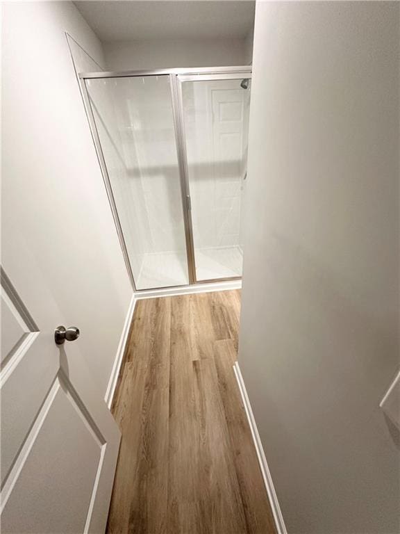 hallway featuring light wood-style floors and baseboards