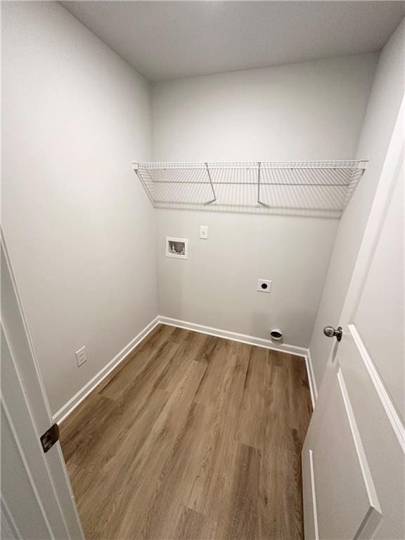 laundry room with electric dryer hookup, washer hookup, wood finished floors, and baseboards