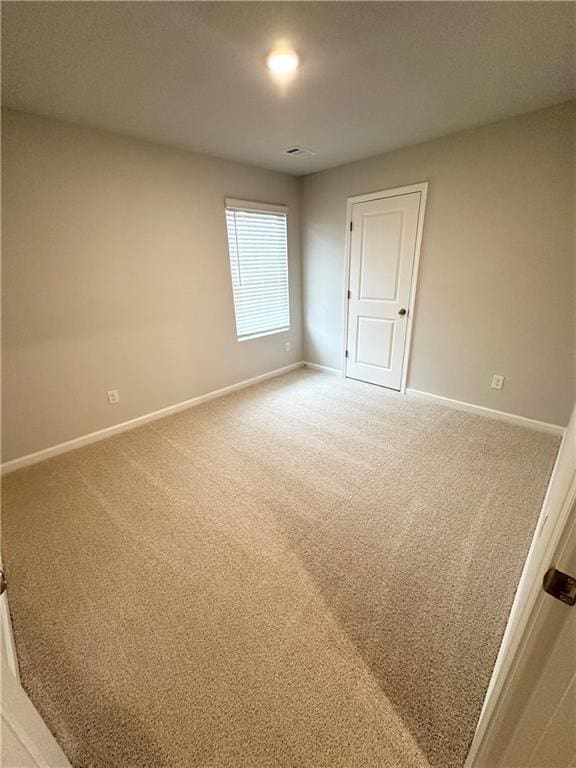 spare room featuring baseboards and carpet floors