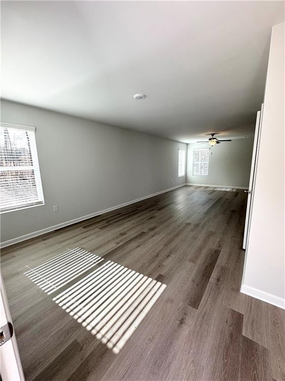 spare room featuring a ceiling fan, wood finished floors, and baseboards