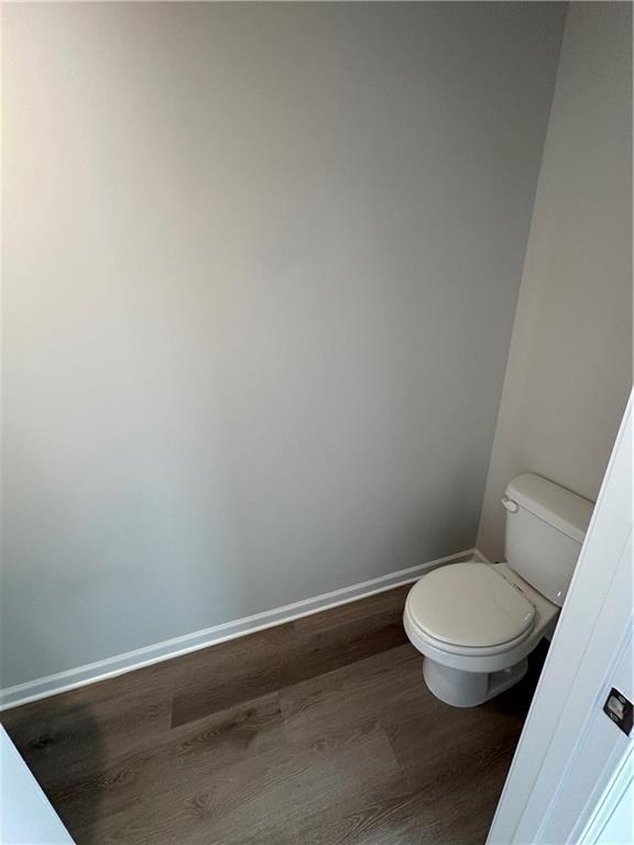 bathroom featuring wood finished floors, toilet, and baseboards