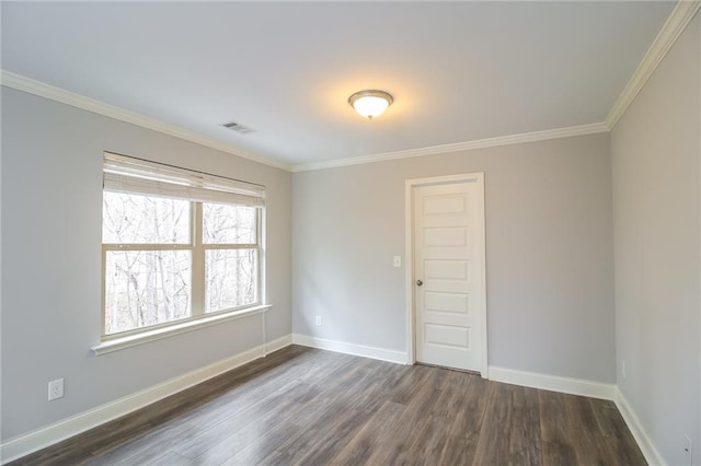 unfurnished room with visible vents, baseboards, crown molding, and dark wood finished floors
