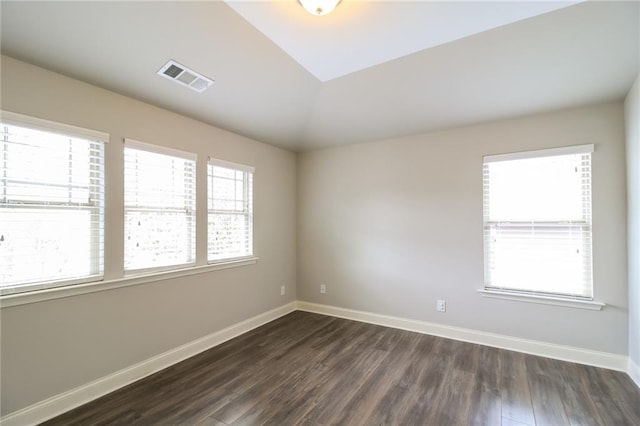 empty room featuring visible vents, baseboards, and dark wood-style floors