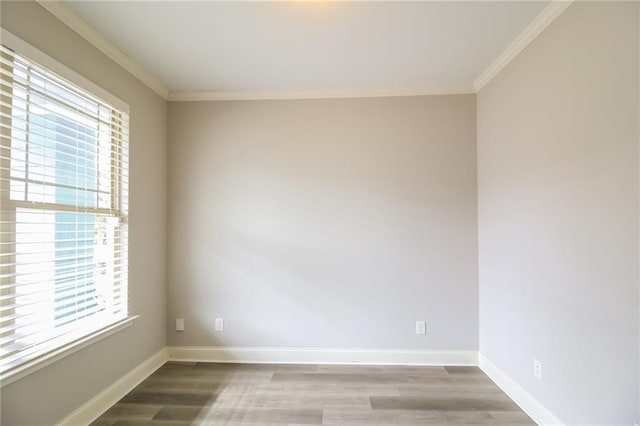 unfurnished room with crown molding, baseboards, and wood finished floors