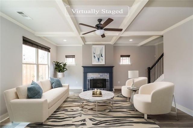 living room featuring a healthy amount of sunlight, a fireplace, baseboards, and visible vents