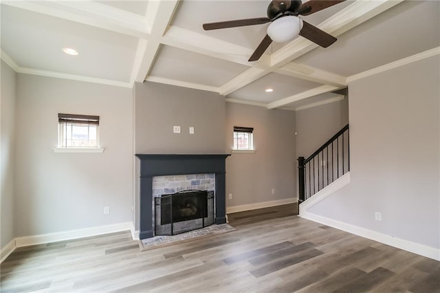 unfurnished living room featuring beamed ceiling, baseboards, coffered ceiling, and a fireplace with flush hearth