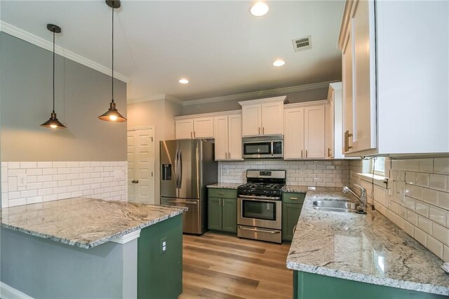 kitchen featuring visible vents, a sink, crown molding, stainless steel appliances, and backsplash