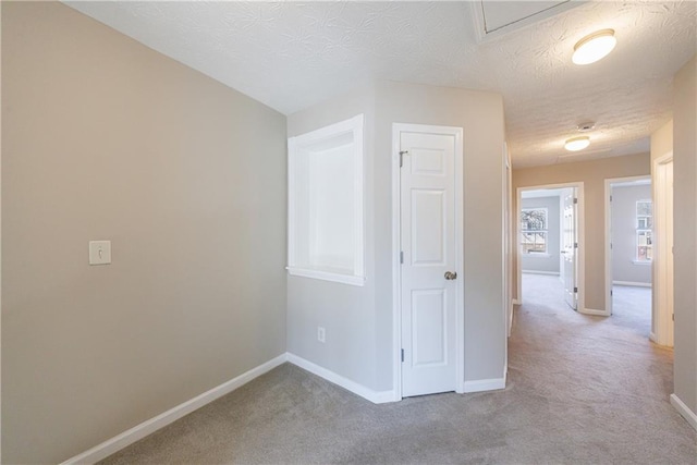 carpeted spare room with baseboards and a textured ceiling