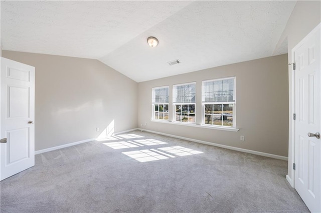 interior space with visible vents, a textured ceiling, lofted ceiling, and carpet floors