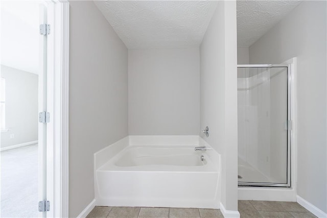 bathroom featuring tile patterned floors, a shower stall, and a textured ceiling