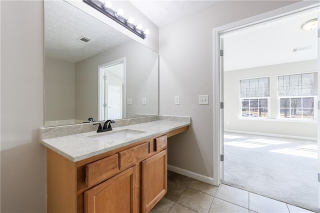 bathroom featuring baseboards, a textured ceiling, vanity, and tile patterned flooring