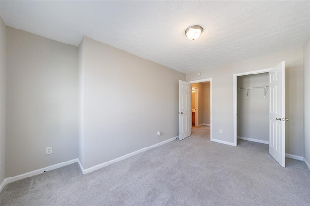 unfurnished bedroom with a closet, baseboards, and light carpet