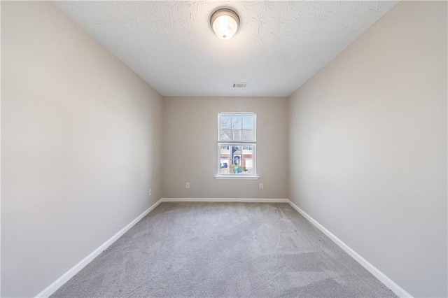 unfurnished room with visible vents, baseboards, a textured ceiling, and carpet flooring