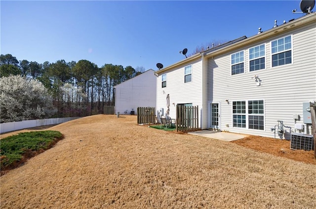 back of property with a patio area, a yard, and fence