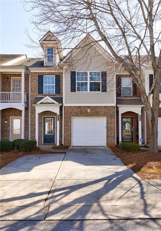 view of front of property featuring concrete driveway, an attached garage, and brick siding