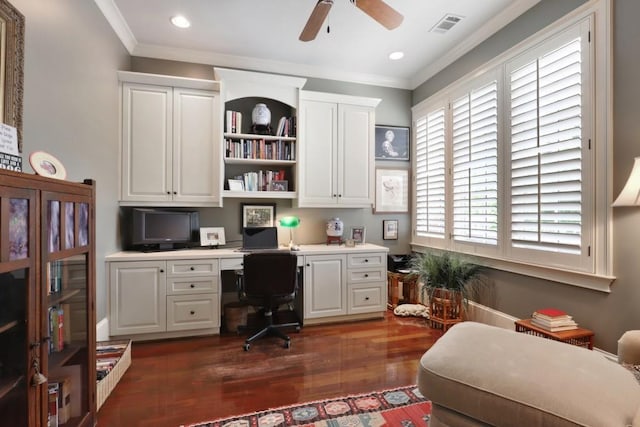 home office with built in desk, ceiling fan, crown molding, and dark hardwood / wood-style flooring