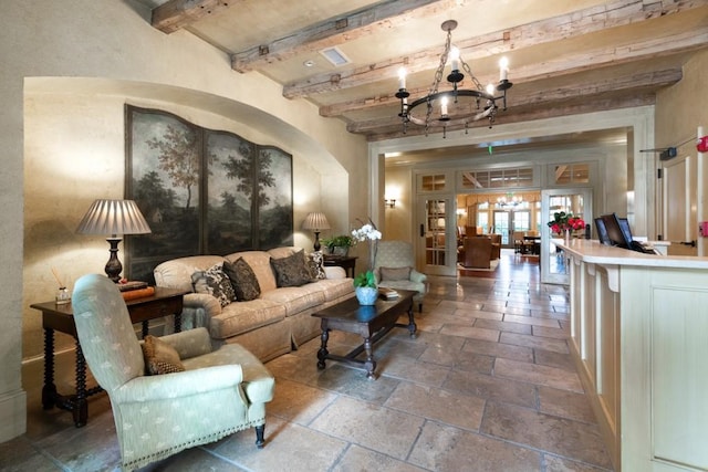 tiled living room with an inviting chandelier, beam ceiling, and french doors