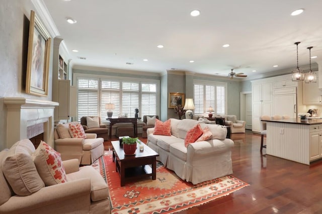 living room with crown molding, wood-type flooring, and ceiling fan with notable chandelier