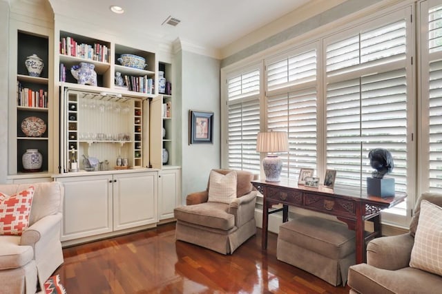 living area featuring dark hardwood / wood-style floors, built in features, and ornamental molding