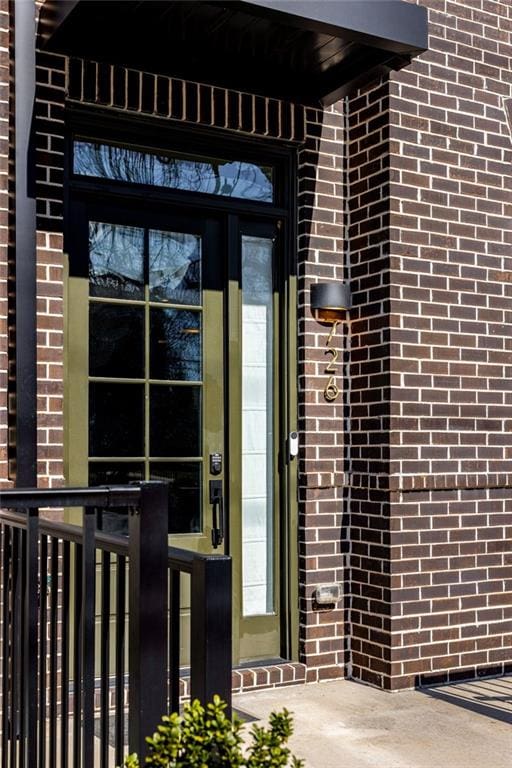 view of exterior entry featuring brick siding