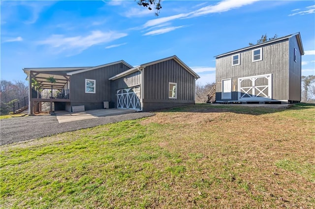 back of house featuring an outbuilding, a yard, and a barn