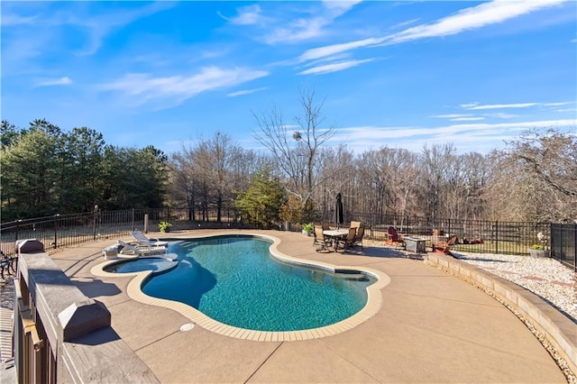 view of swimming pool featuring a pool with connected hot tub, a patio, and fence