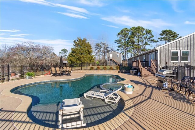 view of pool with area for grilling, fence, a wooden deck, a fenced in pool, and a patio area