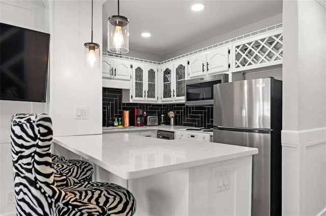 kitchen with kitchen peninsula, white cabinetry, hanging light fixtures, and appliances with stainless steel finishes