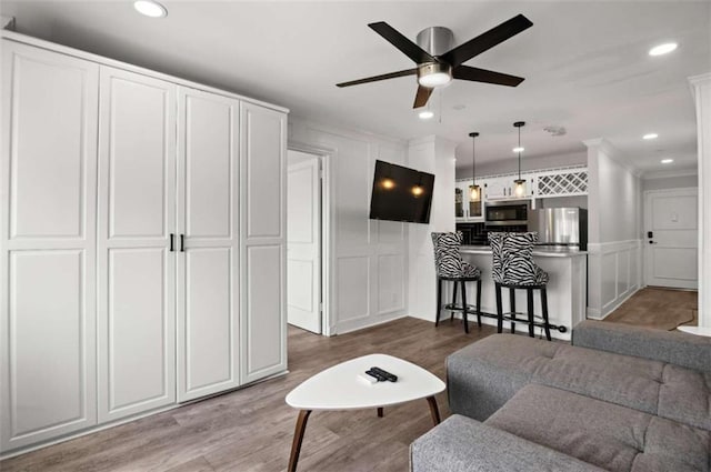 living room featuring ceiling fan and dark hardwood / wood-style flooring