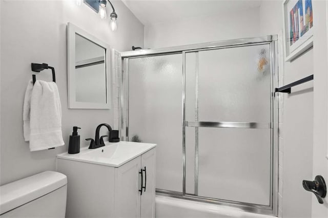 full bathroom featuring combined bath / shower with glass door, vanity, and toilet