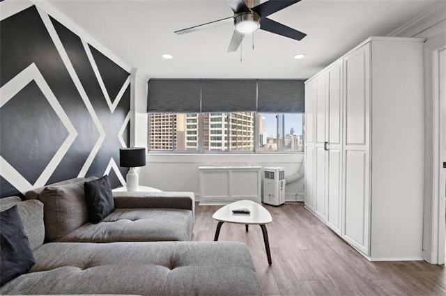 sitting room with ceiling fan, ornamental molding, and light hardwood / wood-style flooring