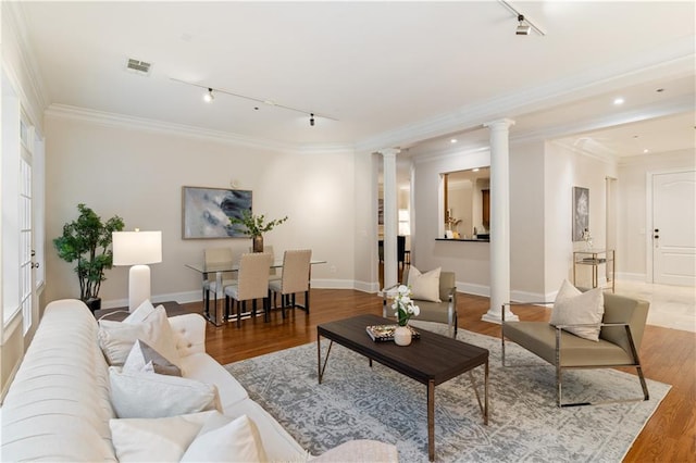 living room featuring track lighting, crown molding, hardwood / wood-style flooring, and decorative columns