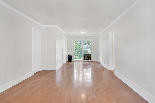 empty room featuring crown molding and light hardwood / wood-style flooring