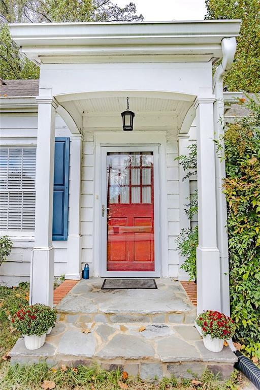 entrance to property featuring roof with shingles