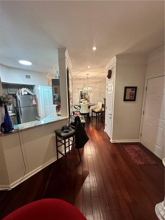 200 Renaissance Pkwy NE Unit 305, Atlanta, GA 30308 - hallway with a chandelier, dark wood-type flooring, baseboards, recessed lighting, and ornamental molding