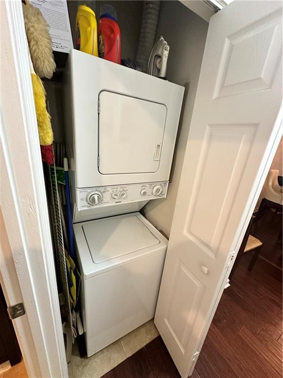 200 Renaissance Pkwy NE Unit 305, Atlanta, GA 30308 - washroom with stacked washer / dryer and wood finished floors