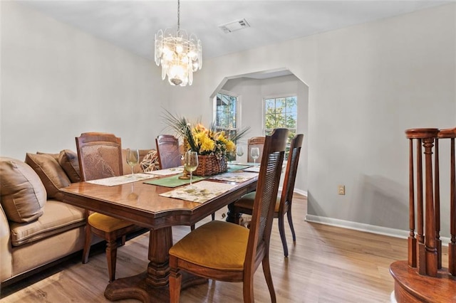 dining room with an inviting chandelier and light hardwood / wood-style flooring